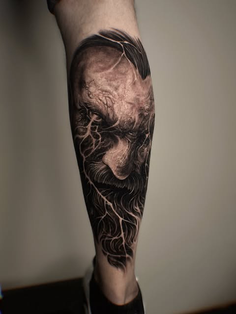 Dark portrait tattoo on a client's lower leg